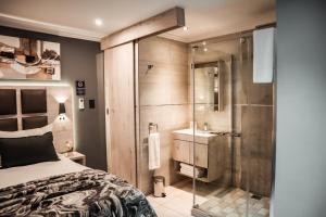 a bedroom with a shower and a bed and a sink at Cascades Guest Lodge in Nelspruit