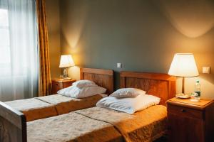Wojanów的住宿－帕拉斯沃間諾酒店，一间卧室配有两张床和一盏灯