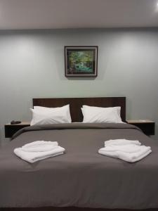 Una cama con dos toallas blancas encima. en Rawai Sea Beach en Phuket