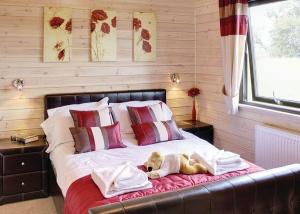 a teddy bear laying on a bed in a room at Nunland Hillside Lodges 