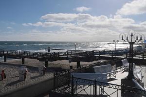 a beach with benches and a pier and the ocean at Parkblick - 01-06 in Kühlungsborn