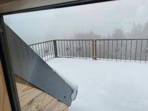 d'un balcon avec de la neige à l'extérieur d'une fenêtre. dans l'établissement FeWo am Fusse der Landeskrone mit Sauna, à Görlitz