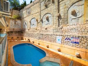 a swimming pool in front of a stone building at Apartamento en Altea con vistas al mar in Altea