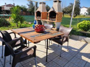 een houten tafel en stoelen op een patio bij Alojamento local A Giesta in Sao Sebastiao da Giesteira