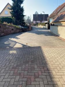 a cobblestone street in a town with a building at Gîte des cigognes in Sermersheim