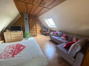 1 dormitorio con 1 cama grande y 1 sofá en Gîte des cigognes, en Sermersheim