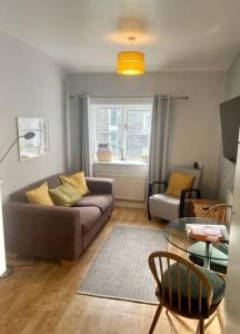 a living room with a couch and a table at Courtyard Flat - Kendal in Kendal