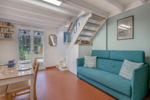 sala de estar con sofá azul y mesa en Maison a 150 metres de la mer au Pouliguen!, en Le Pouliguen
