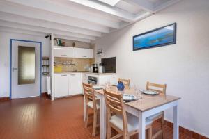 cocina con mesa de comedor y sillas en Maison a 150 metres de la mer au Pouliguen!, en Le Pouliguen