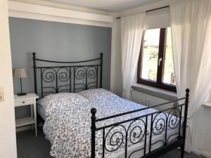 a bedroom with a black bed and a window at Gästehaus Moin Allgäu in Immenstadt im Allgäu