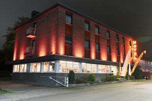 un edificio de ladrillo rojo con luces encendidas por la noche en Hotel Stadt Grevenbroich, en Grevenbroich