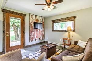 a living room with a couch and a ceiling fan at Lake Pepin Cottage with Patio - Walk to the Marina! in Pepin