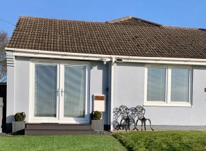 a white house with a bench in front of it at Poppy Annex in Wellow