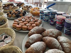 a table topped with plates of donuts and drinks at Hotel Tre Stelle Gabicce Mare in Gabicce Mare