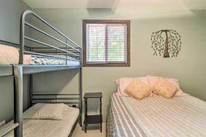 a bedroom with a bunk bed next to a bunk bed gmaxwell gmaxwell gmaxwell at Higgins Lake Getaway with Fire Pit, Walk to Beach! in Roscommon