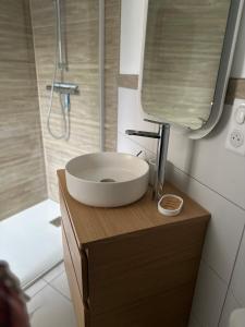 y baño con lavabo blanco y espejo. en Chez Alice - Isigny le Buat, en Isigny-le-Buat