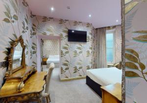 1 dormitorio con cama, espejo y escritorio en The Coal Exchange Hotel en Cardiff