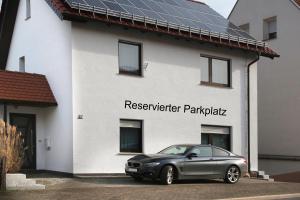 a car parked in front of a house with solar panels at Ferienwohnung Büren in Büren