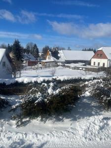 a snow covered village with houses and a fence at Apartmán Studnice na Vysočině in Nové Město na Moravě