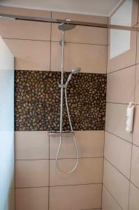 een douche met een douchekop in de badkamer bij The Originals City, Hôtel Bristol, Le Puy-en-Velay in Le Puy en Velay