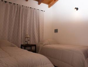 1 dormitorio con 2 camas y ventana en Casa confortable en Luján de Cuyo, Mendoza. en Luján de Cuyo