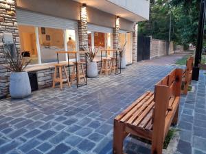 un patio con un banco, mesas y un bar en Hotel Rincón de Playa en Miramar