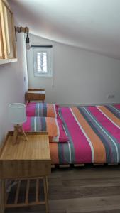 1 dormitorio con 1 cama con una manta a rayas de colores en Adorable petite maison au coeur du Luberon, en Villelaure