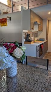 um vaso de flores sentado numa mesa numa cozinha em Adorable petite maison au coeur du Luberon em Villelaure