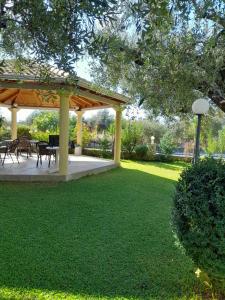 a pavilion with a table and chairs on a lawn at Eleonas Apartments in Riza