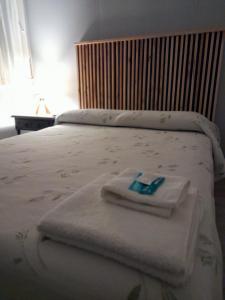 1 dormitorio con 1 cama con toallas en Hotel Rincón de Playa en Miramar