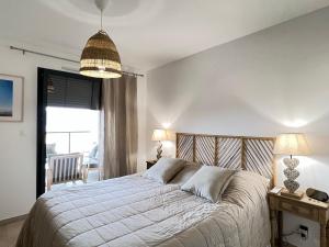 a bedroom with a bed and a table and a window at BEL'ORIZONTE C, 100m des plages et vue mer in Propriano