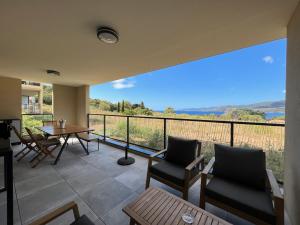 a room with a balcony with a table and chairs at BEL'ORIZONTE C, 100m des plages et vue mer in Propriano