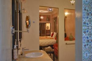 a bathroom with a sink and a room with a bed at Riad Tama & spa in Ouarzazate
