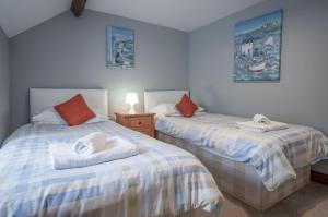 um quarto com 2 camas e toalhas em Rose Coach House - 3 Bedroom Cottage - Pendine em Pendine