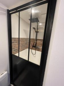 a glass door with a shower in a room at Villa Kiara Hébergements in Cusset