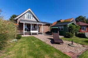 a house with a bench in the yard at Heimathafen 111 in Emden