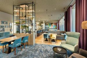 ein Restaurant mit blauen Stühlen und Tischen und eine Bar in der Unterkunft BASSENA Wien Donaustadt in Wien