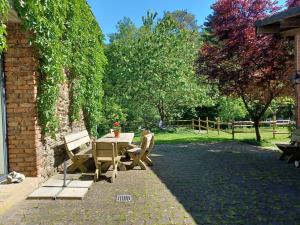 una mesa y sillas en un patio con árboles en Lenzenhaus, en Wallscheid