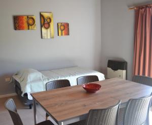 Habitación con mesa con sillas y cama en Departamento completo, cochera, parrilla. Zona Parque Central en Mendoza
