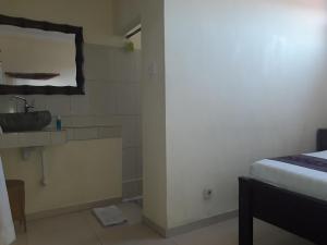 ein kleines Bad mit einem Waschbecken und einem Waschbecken in der Unterkunft Adi House Homestay in Ubud