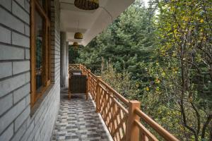 a porch of a house with a view of trees at Serenity Stays - Manali, Naggar in Nagar