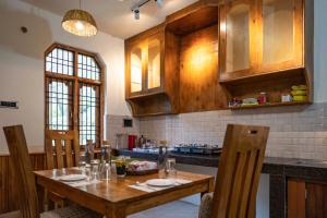 a kitchen with a wooden table with chairs and a tableablish at Serenity Stays - Manali, Naggar in Nagar