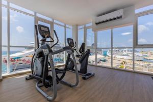 a gym with two exercise bikes in a room with windows at HH-2Bdr510 - Luxury Oceanfront Modern apartment in Aruba in Oranjestad
