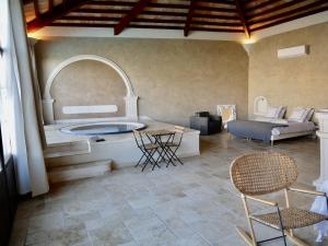 sala de estar con bañera, mesa y sillas en Le Pool House - Private Jacuzzi - Mas des Sous Bois en Ventabren