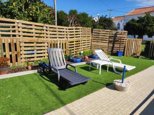 two chairs sitting on the grass in a backyard at Alojamento local A Giesta in Sao Sebastiao da Giesteira