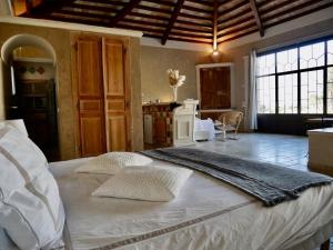 a bedroom with a large white bed with two pillows at Le Pool House - Private Jacuzzi - Mas des Sous Bois in Ventabren