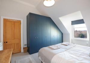 a bedroom with a large bed with blue cabinets at The Botanics Residence in Edinburgh