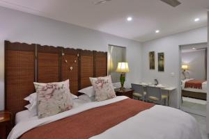 a bedroom with a large bed with a desk and a room at Strandkiewiet in Jacobs Bay