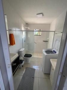a white bathroom with a toilet and a sink at Casa deck caixa d´aço in Porto Belo