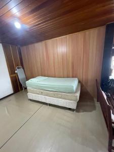 Cama en habitación con pared de madera en Casa deck caixa d´aço, en Porto Belo